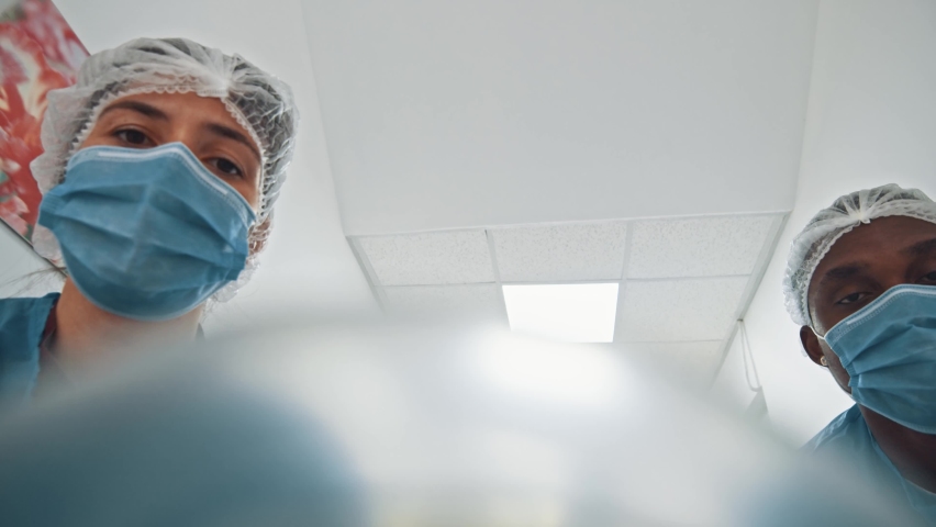 POV shot of patient seeing several paramedic multi-race doctors running with stretcher bed to hospital operating room for surgery. Motion scene. Medical. | Shutterstock HD Video #1062955666