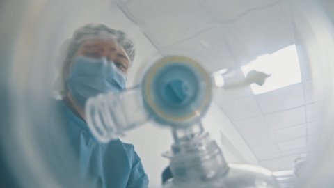 POV shot of patient seeing young doctor or nurse wearing breathing mask on his face hurrying running for emergency department. Motion scene. Close-up.
