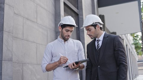 Group Business man and engineer walking Talk work in the building Or office. Use tablet to take note And meeting construction, addition, and amendment to location. Concept key worker teamwork