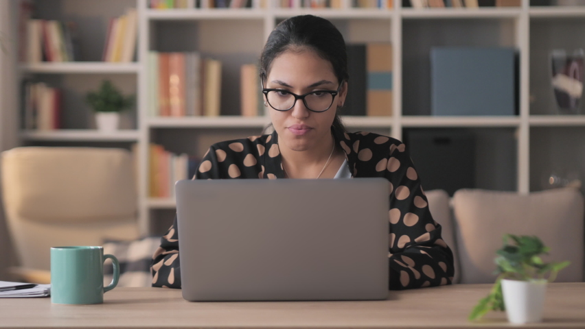mixed race frustrated exhausted businesswoman works at computer from home,young middle eastern woman entrepreneur upset stressed typing at the laptop reading bad news on social media Royalty-Free Stock Footage #1062956923