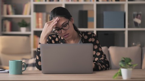 mixed race frustrated exhausted businesswoman works at computer from home,young middle eastern woman entrepreneur upset stressed typing at the laptop reading bad news on social media