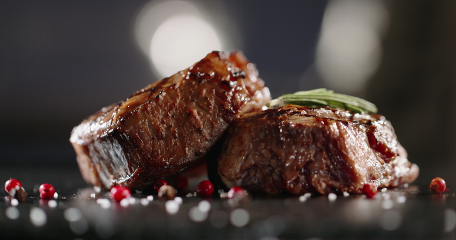 Grains of salt and other spices falling onto plate with beautiful beef steak. Mignon fillet being prepared for serving - art food, gourmet meal 4k footage close up | Shutterstock HD Video #1062959542