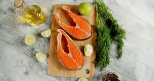 Raw salmon steaks on a cutting board rotate. On a white background. Top view. 