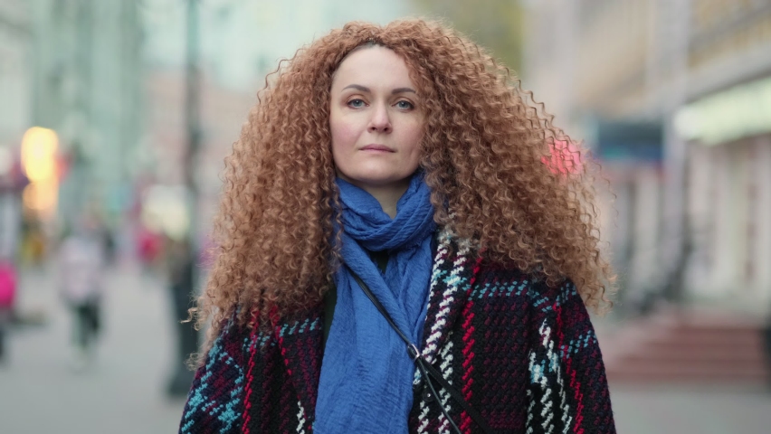 beautiful young woman looking at camera and smiling joyfully. Happy face on street at sunlight. Positive portrait outside. Close up. Slow motion