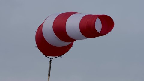 Windsock with cloudy sky in the background.