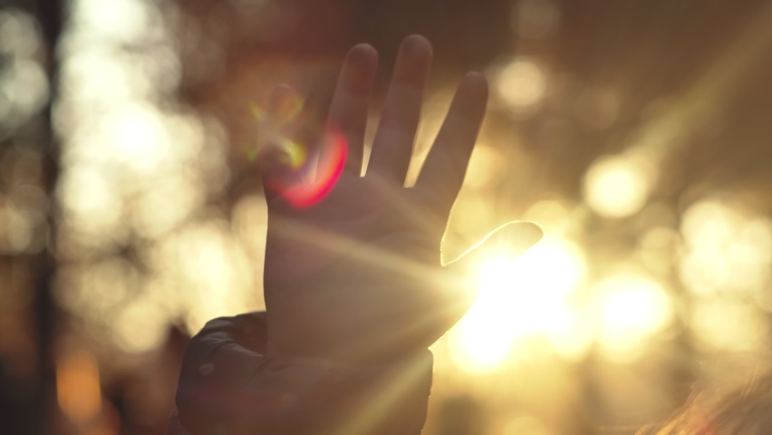 Closeup of hand of child play with sunlight. Sun shines through small fingers. | Shutterstock HD Video #1062980053