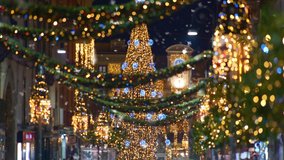 First snow falling for new year holidays. White snowflakes whirl and fall on the city streets. Christmas european city illuminated with holiday lights. - Powered by Shutterstock - Get 15% off with code: PIKWIZARD15