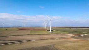 Aerial view of windmills farm for energy production. Wind power turbines generating clean renewable energy for sustainable development. High quality 4k footage