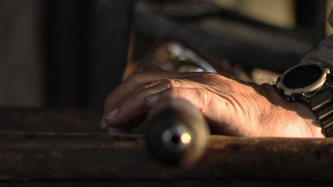 Glass Artisan at Work. Hand of a Glass Maker, Master Craftsman, shaping Glass with a Rod. Close Up.