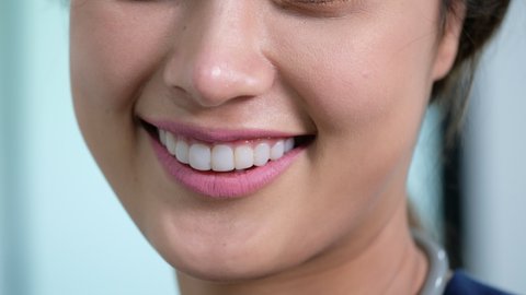 Close up smiling Asian woman mouth shows healthy white tooth with beautiful lips also present part of woman face look to camera, Asian beauty.  