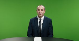Male newsanchor informing about current news. Professional television live reporter talking about recent global events in business and politics. Chroma key green background 4k footage