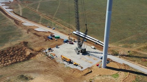 Drone footage of a wind turbine construction site, heavy machinery, big crane 4k