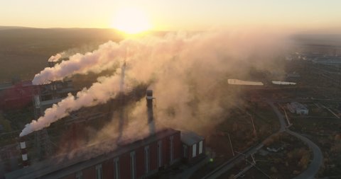Smoking chimneys of industrial buildings complex at sunset. Heavy industry from above. Aluminum production Aerial 4K High Pollution From smoking smokestacks