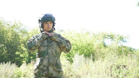 Military female is wearing soldier outfit, suit, preparing for war.