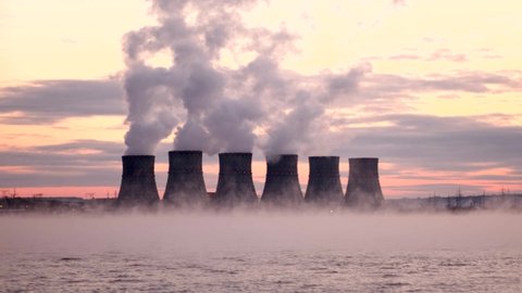 A nuclear power plant releases chemicals into the air through pipes. Environmental pollution, ecology, air emissions