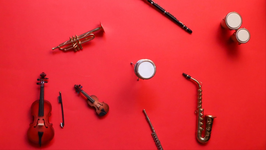 Moving instruments of jazz band or symphonic orchestra against red background, stop motion animation | Shutterstock HD Video #1063018903