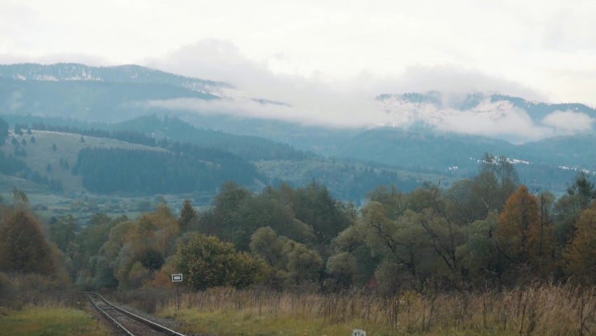 Railroad tracks cutting it´s way through a forest with amazing view of surrounding lanscape covered in haze and white clouds, Slovakia, Horehronský expres, banska bystrica. Interrail.