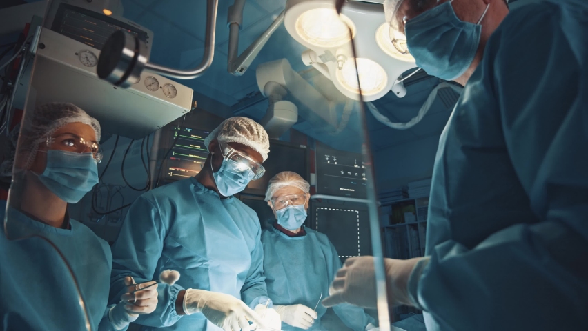 Professional surgeon teaching younger interns performing organ surgery transplant operation with modern equipment. Futuristic mock-up animated hologram panel. Technologies. Royalty-Free Stock Footage #1063026550