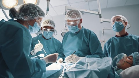 Professional surgeon performing heart transplant operation for male patient in modern hospital. Man undergoing heart surgery. Medical. Healthcare.