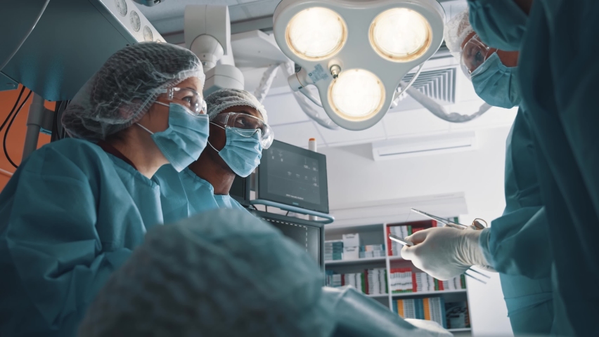 Multi-ethnic collaborative team of medical employees doing surgical operation together communicating and finishing. Surgery. Healthcare. Royalty-Free Stock Footage #1063026613