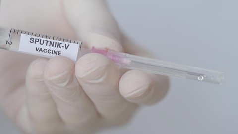 Doctor's Hand Attaching Needle To Syringe Sputnik-V Vaccine. close up