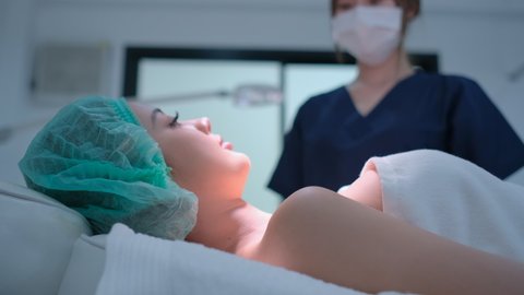 Beauty clinic staff come to talk and discuss with beautiful client woman who lie on bed and look relax. Concept of beauty clinic for beauty of skin and body business, Asian beauty salon. 