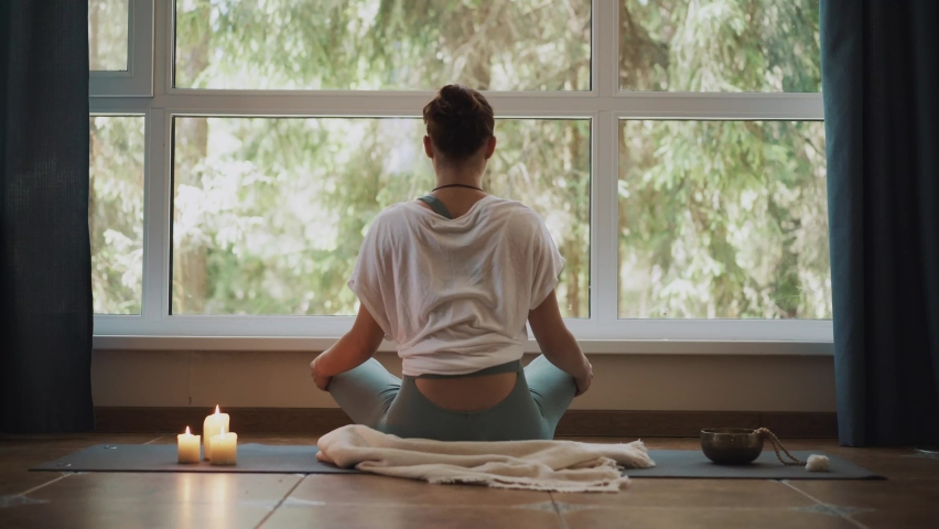 Unrecognized back side Shot of woman sitting in meditation pose yoga indoors Window background. 
Hands in healing  mudras gesture. Female mental and body health Royalty-Free Stock Footage #1063031128