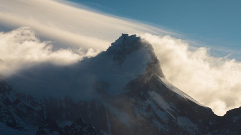 Time lapse showing clouds rolling over the snow-covered main summit of Cerro Pine Grande, located in Torres del Paine National Park.