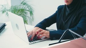 Cropped view of muslim businesswoman using laptop in office