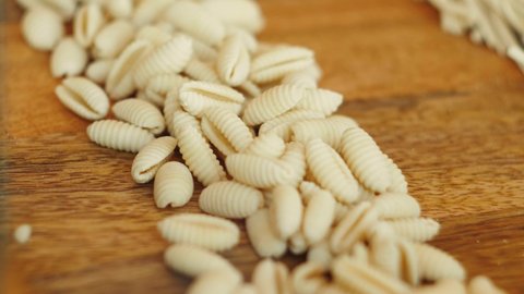 Home made pasta on the table with flour. Fresh pasta with wheat flour. Penne rigate Fresca pasta. Traditional italian food, high haute kitchen restaurant.