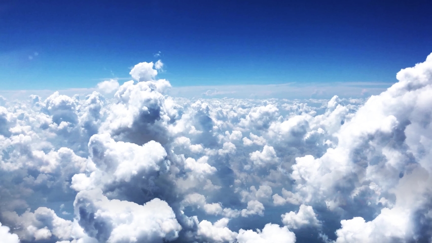 Amazing timelapse of soft white clouds moving slowly on the clear blue sky in pure daylight.Flying through beautiful thick fluffy clouds.  Direct view from the cockpit. Royalty-Free Stock Footage #1063038973