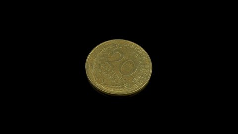 French 20 centimes coin from 1983 rotating on a black background.