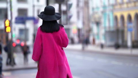 female city dweller is walking in downtown, dressed stylish coat and hat, rich and luxury woman