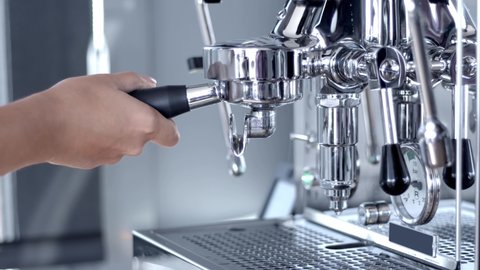 Home one group metallic steel coffee machine. Woman barista inserting double porta filter to make espresso coffee. High quality video 4k still footage.