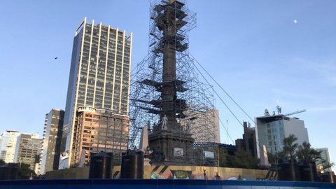 Mexico City , Mexico - 10 24 2020: October 24 2020, Mexico City, Mexico: Column of the angel of independence in process of restoration with a beautiful clear blue sky and the moon on the