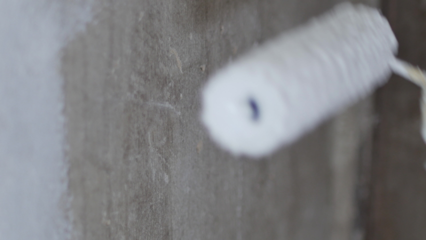 Close Up Shot of White Paint being applied on a wall. Room Renovations at Home concept. Painter man painting the wall in home, with paint roller and white color paint. Room renovations at house Royalty-Free Stock Footage #1063058167