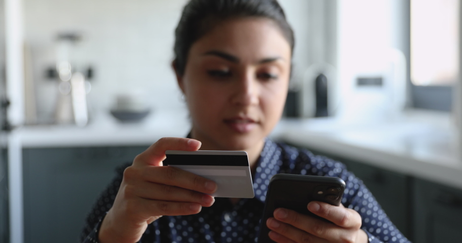 Close up head shot stressed nervous young indian ethnic woman having troubles with financial operations, entering wrong payment information from credit banking card into mobile phone application. Royalty-Free Stock Footage #1063058686