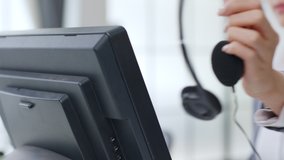 Closeup hand of businesswoman call center taking headphone or headset on computer. customer service, hotline, helpline concept - Powered by Shutterstock - Get 15% off with code: PIKWIZARD15