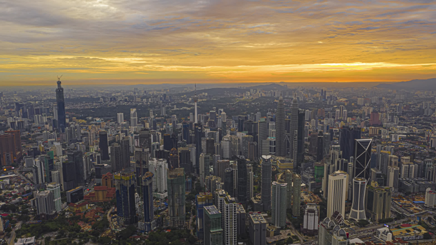 Time lapse: Beautiful and dramatic golden hour view of the Kuala Lumpur skyline overlooking the national landmarks,  the Petronas Towers and Kuala Lumpur Tower. Golden hour.  | Shutterstock HD Video #1063063330
