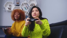 Two young woman using joystick controller playing video game on. Competition win and loss. High quality 4k footage