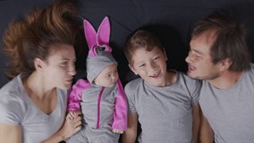 Happy family with her kids are making a selfie or video call to father or relatives in a bed. Concept of technology, new generation,family, connection, parenthood, authenticity.