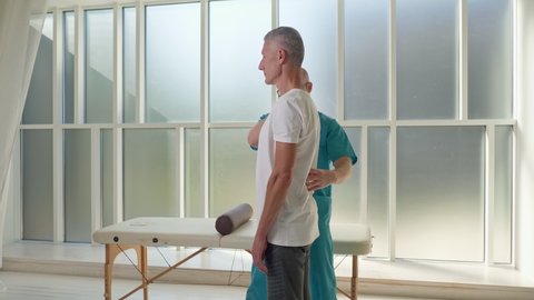Physiotherapist Conducting a Therapy Session With an Older Man in a Rehabilitation Center. Sports Physiotherapy Concept.