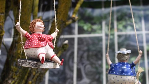 funny clay figurines on a swing