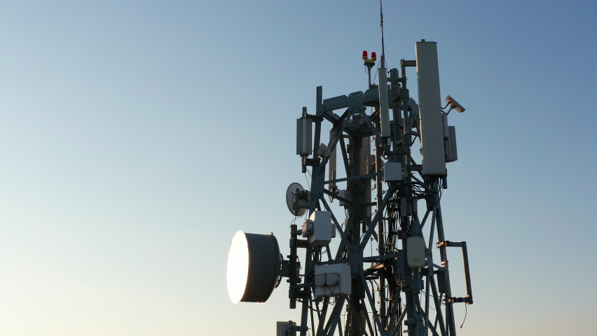 Silhouette of a communication tower for 5G network featuring cellular microwave wireless directional antenna of radio relay link used for mobile telecommunication. Royalty-Free Stock Footage #1063091755