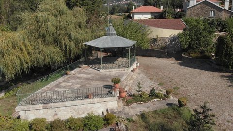 DRONE AERIAL FOOTAGE: Traditional bandstand rotunda with a weathercock on top at large mansion estate near Esposende, Portugal. 
