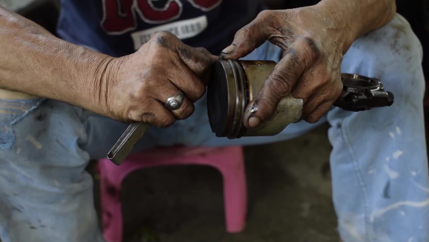 Car engine repair technician removing piston ring