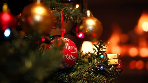 Christmas Decorations With Cinematic Detail Of Bauble On Tree, Relaxing Scene At Home In Front Of Warm Fire.