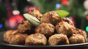 Man hands taking Pork stuffing meatballs. Christmas, decoration, gifts, green tree branch. Rotating video