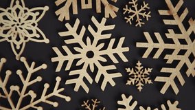 Handmade wooden snowflakes filmed in flay lay on black background with zoom in effect.4K ultra hd footage  of eco friendly holiday decorations for Christmas Eve and New Year celebration party decor