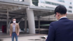 Business people Caucasian with Asian man colleague partnership wearing protective face mask for protect covid-19 virus discussing business project plan with using digital tablet computer in the city - Powered by Shutterstock - Get 15% off with code: PIKWIZARD15